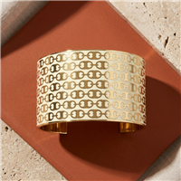 Tory Burch Gemini Link 1.2 inch wide cuff bracelet in New Ivory and Tory Gold with repeating signature link motifs, polished gold tone interior, and open cuff silhouette.