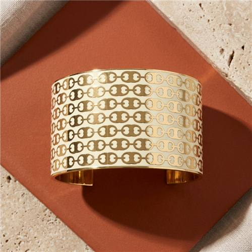 Tory Burch Gemini Link 1.2 inch wide cuff bracelet in New Ivory and Tory Gold with repeating signature link motifs, polished gold tone interior, and open cuff silhouette.