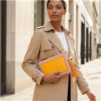 Tory Burch blush pink leather convertible crossbody clutch with marigold yellow front pocket, matching long tassel, slim shoulder strap and polished metal hardware.