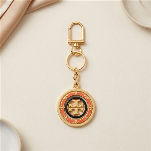 Tory Burch rotating Geo logo key fob bag charm with multicolor circular geometric design, spinning center T logo, gold tone clip, chain, and split key ring.