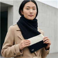 Tory Burch black merino wool ski scarf with contrasting white mohair stripe, ribbed knit texture, and small logo detail, measuring approximately 70 x 9 inches.