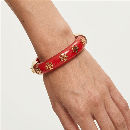 Tory Burch Kira glossy red resin bangle bracelet with repeating gold tone T logo charms, gold hardware, 2.25 inch diameter, and 0.5 inch width.