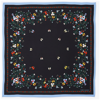Tory Burch black silk square scarf with multicolor floral and botanical print, red and green accents, and contrasting soft blue border, styled as a neckerchief.
