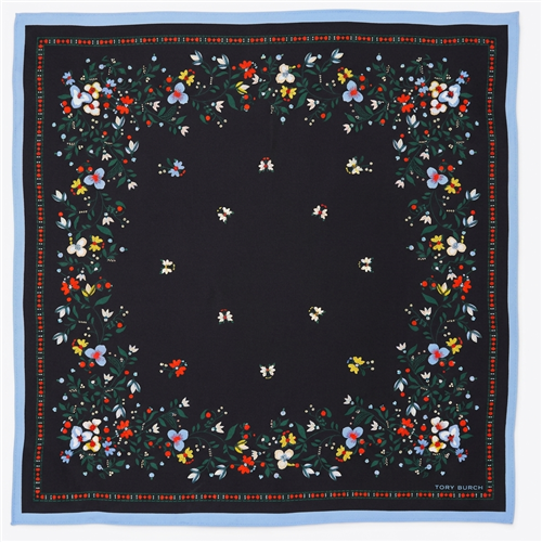 Tory Burch black silk square scarf with multicolor floral and botanical print, red and green accents, and contrasting soft blue border, styled as a neckerchief.
