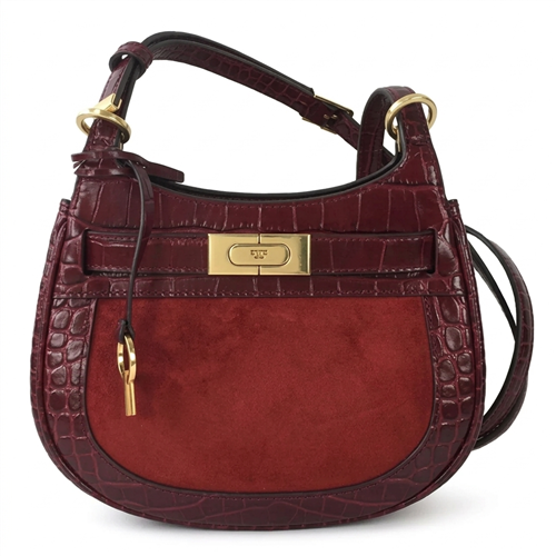 Tory Burch burgundy croc embossed Italian leather saddle crossbody bag with suede front panel, custom golden hardware, belted T lock closure, key hang tag, and adjustable strap.