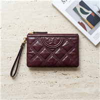 Tory Burch Fleming Soft Waxed wristlet clutch in deep oxblood burgundy leather with diamond quilting, embossed Double T motif, zip top, and matching wrist strap.