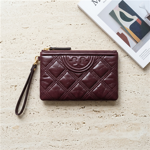 Tory Burch Fleming Soft Waxed wristlet clutch in deep oxblood burgundy leather with diamond quilting, embossed Double T motif, zip top, and matching wrist strap.