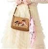 Betsey Johnson The Mane Event brown Western shoulder bag featuring an embroidered running horse with pink ribbon detail, gold tone studs, structured handle, and pink equestrian inspired scarf.