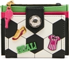 Betsey Johnson Goal Getter soccer card case wallet featuring black and white soccer ball graphics, colorful soccer inspired accents, pink whistle zipper charm, and compact card holder silhouette.