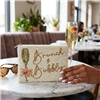 Fashion Culture ivory beaded zip pouch featuring Brunch and Bubbly lettering, a green and gold tone champagne flute, pink floral bow detail, and white zipper.