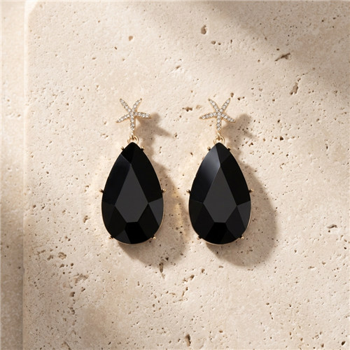 Amrita Singh Hamptons gold tone drop earrings with crystal embellished starfish tops and large faceted black resin teardrop pendants.