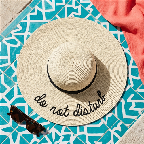 Fashion Culture natural beige floppy wide brim sun hat with Do Not Disturb embroidered lettering, black grosgrain ribbon band, packable woven straw construction, and UV protective design for beach vacations and resort wear.