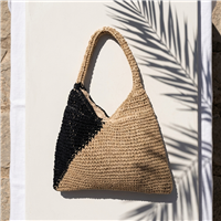 Chic crochet raffia shoulder bag in a natural and black color block design featuring a spacious hobo silhouette with a comfortable shoulder strap for beach vacations, travel, shopping, and everyday summer wear.