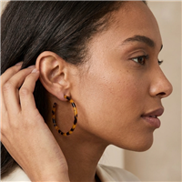 The Bagtique Jewelry Collection Jazlyn  2 inch tortoise shell effect hoop earrings with a slim round silhouette and mottled amber, honey brown, and black pattern.