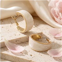 The Bagtique Jewelry Collection wide hoop earrings featuring creamy white acrylic panels framed in polished gold tone metal with a compact chunky curved silhouette.