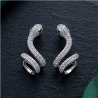 Silver tone crystal snake wrap statement ring with a sculptural coiled serpent design, clear sparkling crystals, and emerald green eye accents.