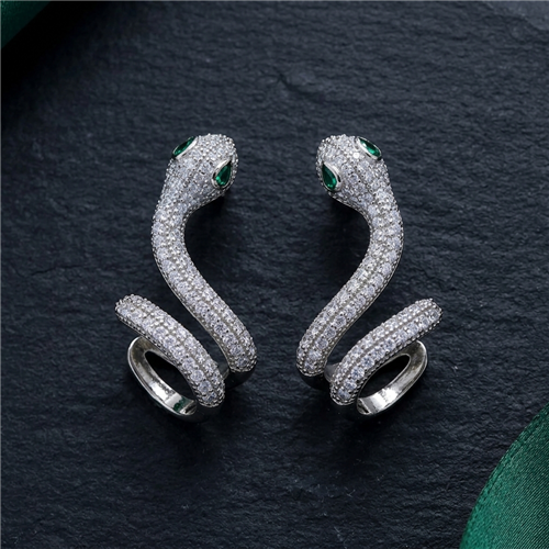 Silver tone crystal snake wrap statement ring with a sculptural coiled serpent design, clear sparkling crystals, and emerald green eye accents.