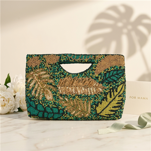 BTC  tropical leaf beaded clutch featuring hand-applied green, teal, olive, and gold beadwork with sequined palm and monstera leaf motifs, cutout handle, removable chain strap, and convertible clutch-to-crossbody styling.