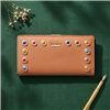 Kate Spade Stacy bifold wallet in masala tan vachetta leather with colorful stone embellishments, goldtone hardware, snap closure, zip pocket, and organized card slots for stylish everyday use.
