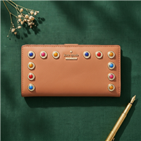 Kate Spade Stacy bifold wallet in masala tan vachetta leather with colorful stone embellishments, goldtone hardware, snap closure, zip pocket, and organized card slots for stylish everyday use.