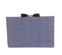 Kate Spade Soft Chambray frame clutch handbag in a soft blue woven fabric with silk trim, featuring a signature engraved bow clasp closure, structured silhouette, and elegant occasion ready styling for weddings, parties, and evening events.