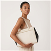 Kate Spade large ivory pebble leather tote bag with contrasting black side panels, double shoulder handles, gold tone hardware, front zipper pocket, and spacious black and white striped interior.
