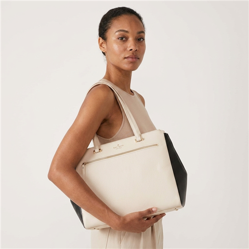 Kate Spade large ivory pebble leather tote bag with contrasting black side panels, double shoulder handles, gold tone hardware, front zipper pocket, and spacious black and white striped interior.