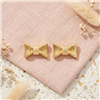 Kate Spade New York gold tone stud earrings featuring dimensional sculpted ribbon bow shapes with polished ridged detailing.