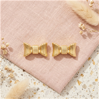 Kate Spade New York gold tone stud earrings featuring dimensional sculpted ribbon bow shapes with polished ridged detailing.