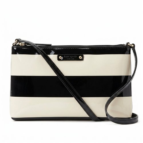 Kate Spade New York crossbody bag featuring bold black and cream horizontal stripes in glossy patent PVC with a zip top closure, lined interior, and long shoulder strap for hands free everyday wear.